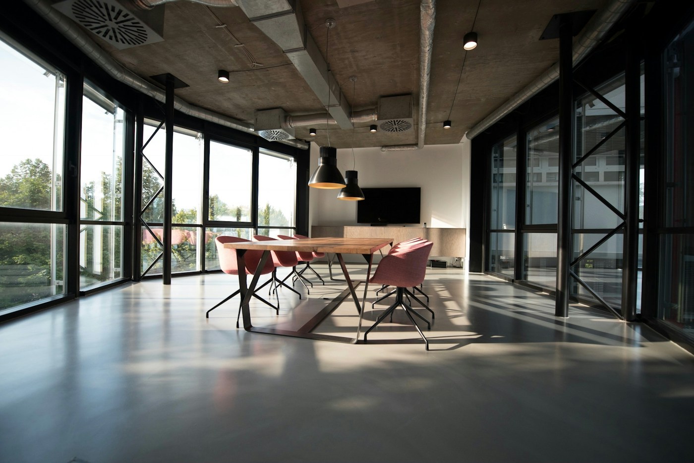 Light-filled workspace with plants and shared tables for purposeful digital collaboration