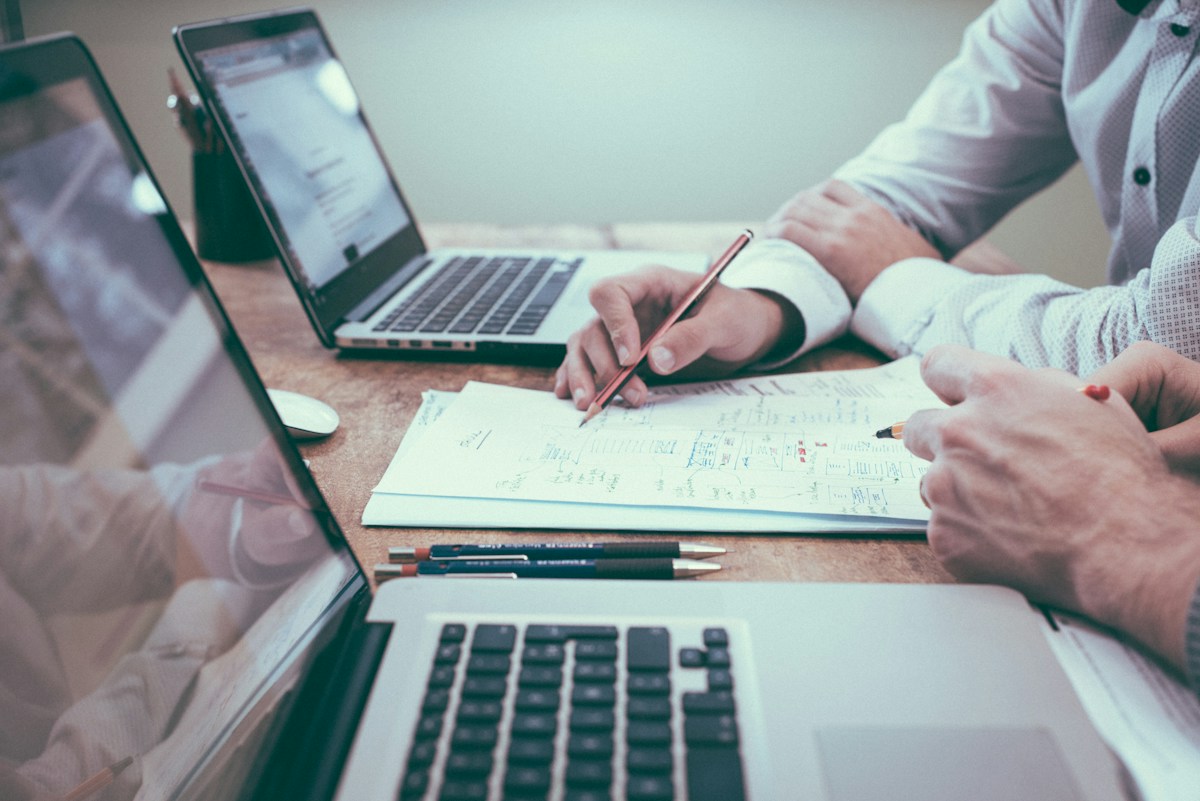 Project planning with documents and a laptop to turn insights into measurable implementation
